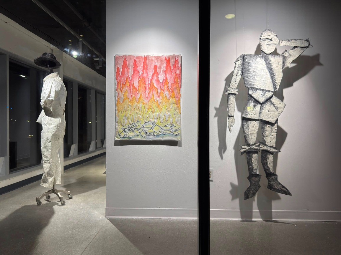 An art gallery displays contemporary artwork includi
 ng white textile sculptures and a painting with red\, yellow\, and orang
 e above blue